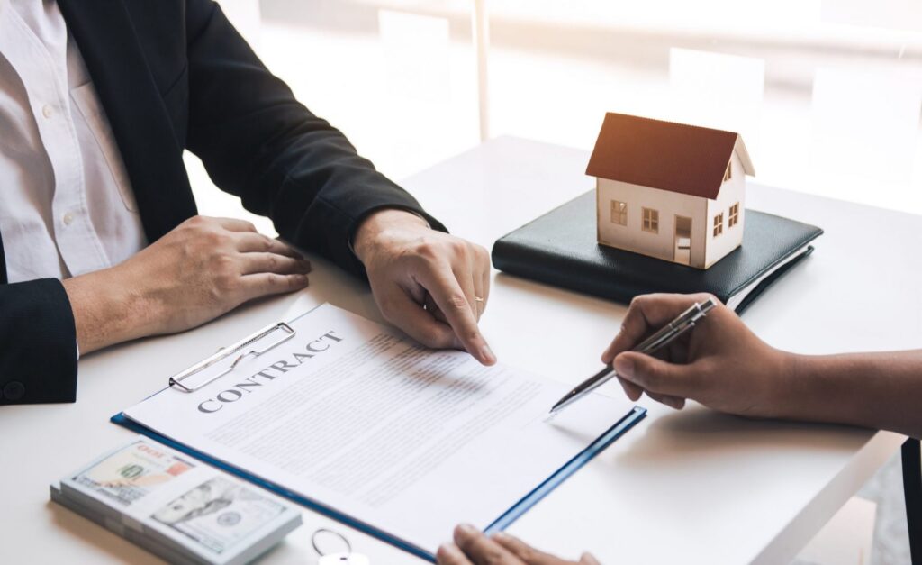 A conveyancer is guiding the client on where to sign on the contract.